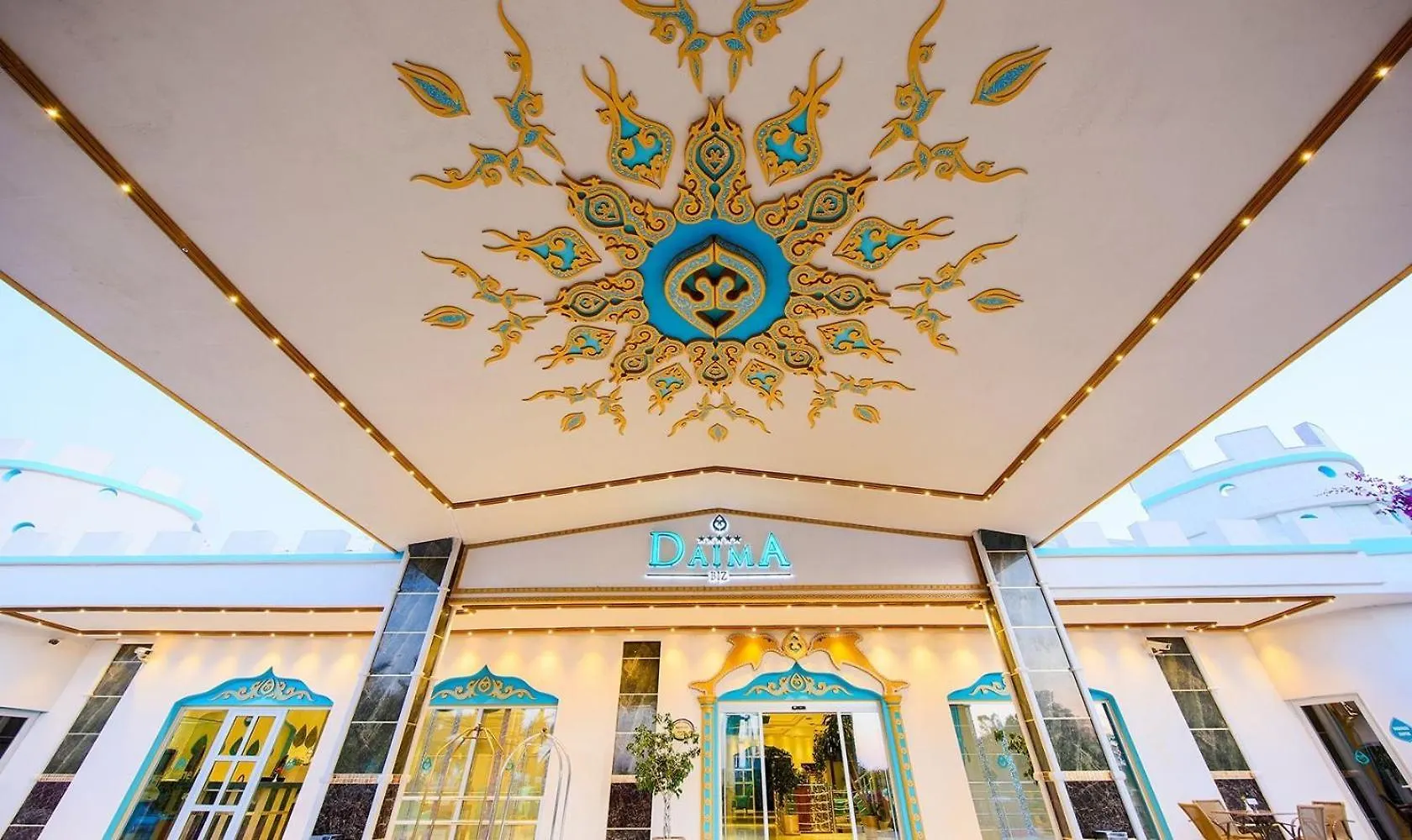 Daima Biz Hotel - Dolusu Aquapark Access Kemer Exterior photo This is a photograph of an elaborately decorated ceiling and the façade of a building, likely a hotel, restaurant, or high-end venue.

**Ceiling Detail:**
The most striking feature is the large, ornate ceiling decoration. It is predominantly white or